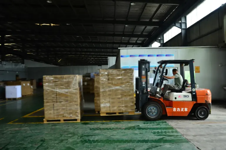 Pallets of shrink-wrapped children's book cartons being moved by forklift in the warehouse